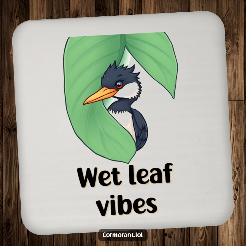 Funny Cormorant Coaster: A small coaster displaying a funny cormorant playfully peeking from behind a large, wet leaf.