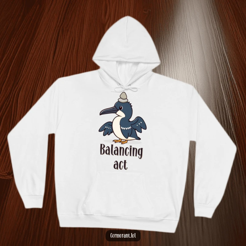Funny hoodie featuring a kawaii cormorant bird concentrating on balancing a small pebble on its head.